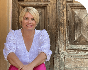 Jenny Vile sitting down wearing white shirt and smiling